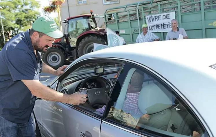 Olivier Boulat, président de la FDSEA distribue des verres de lait aux automobilistes lors de la manifestation.