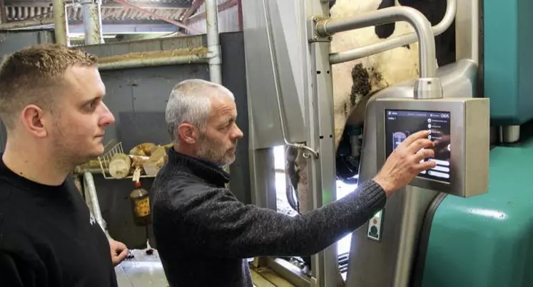 Gaëtan Maurice et Jérôme Merlin contrôlent depuis la fosse, alors qu'une vache est traite sur le robot entièrement automatique, particulièrement compact.