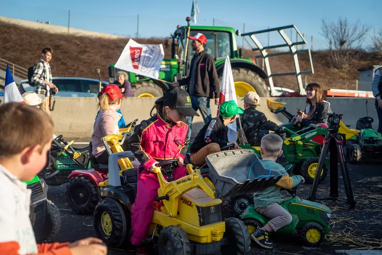 Un groupe d'enfants sur des tracteurs à pédales.