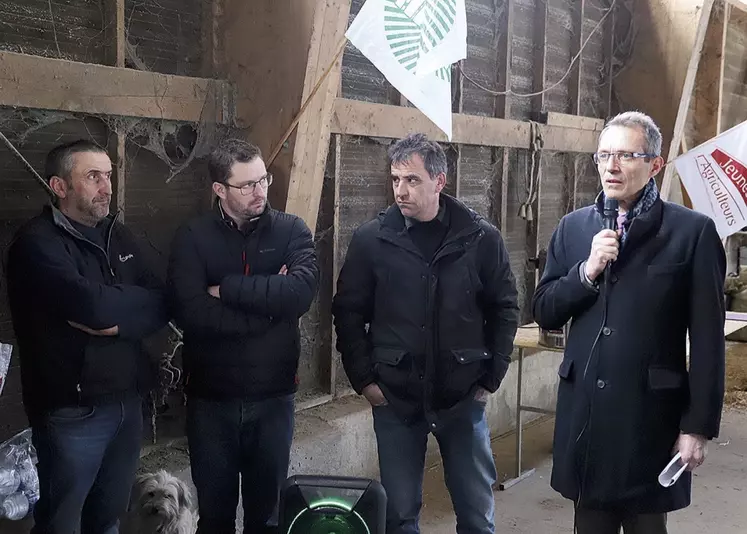 Le préfet de Lozère, Philippe Castanet, parle au micro en réponse aux demandes des agriculteurs, dans une étable.