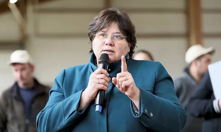 Christine Valentin parle dans un micro en levant le doigt.