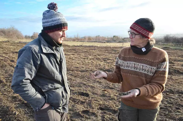 Un homme et une femme discute sur une parcelle de terre.