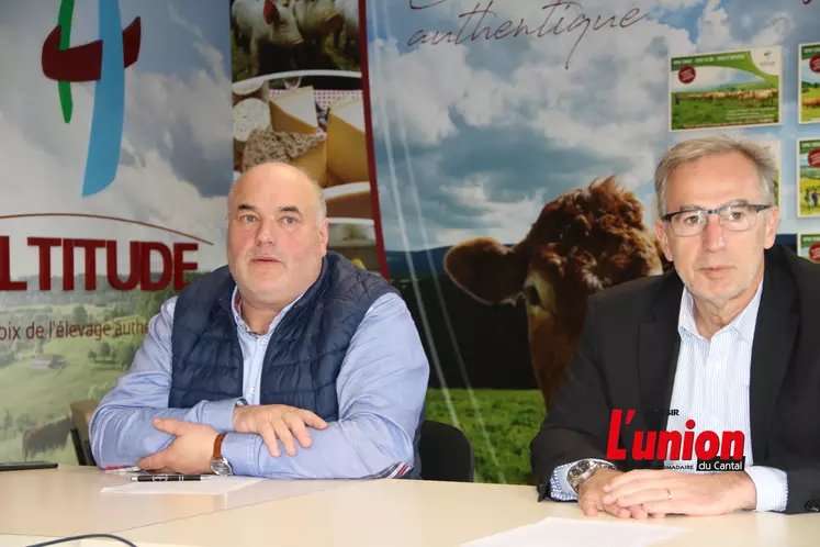 Deux hommes devant les affiches du groupe Altitude.