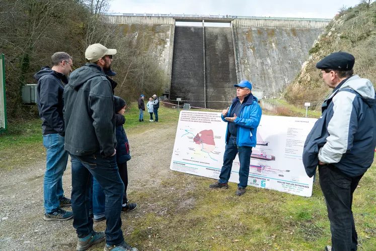 Un groupe de personnes devant un barrage hydraulique.