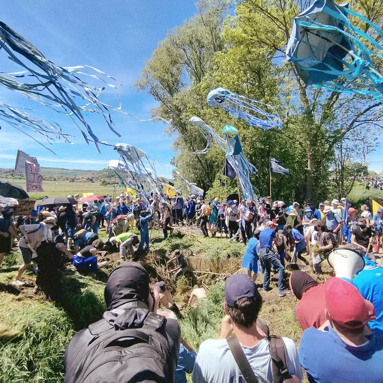 Un grand groupe de personnes manifeste dans la campagne.