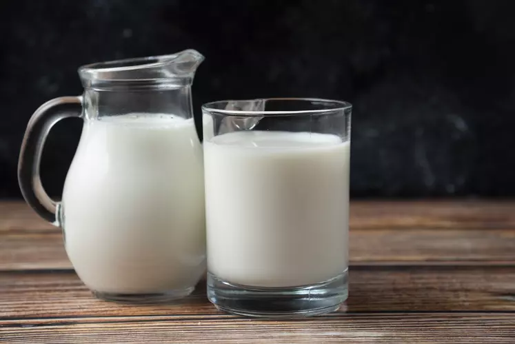 carafe de lait et verre de lait sur une table fond noir