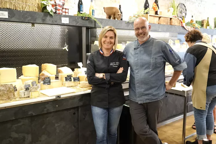 Un homme et une femme posent devant un rayon de fromages