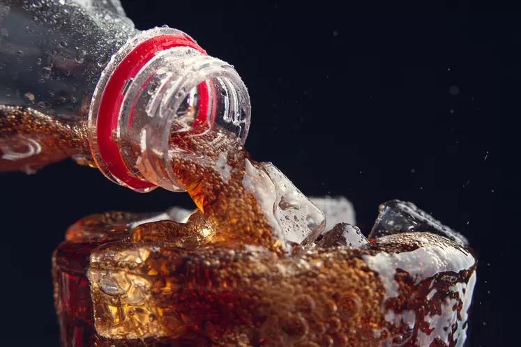 bouteille versant du soda dans un verre