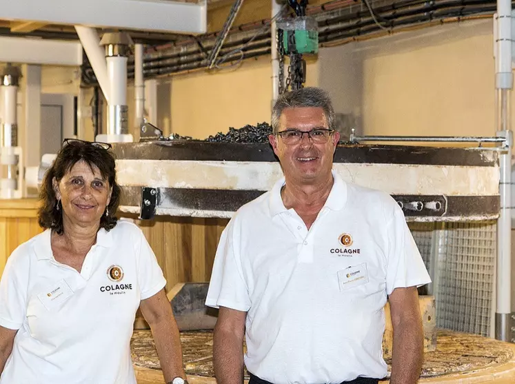 Chantal Rech et Jean-Pierre Constans, les co-directeurs du moulin de Colagne devant la meule de pierre en silex.