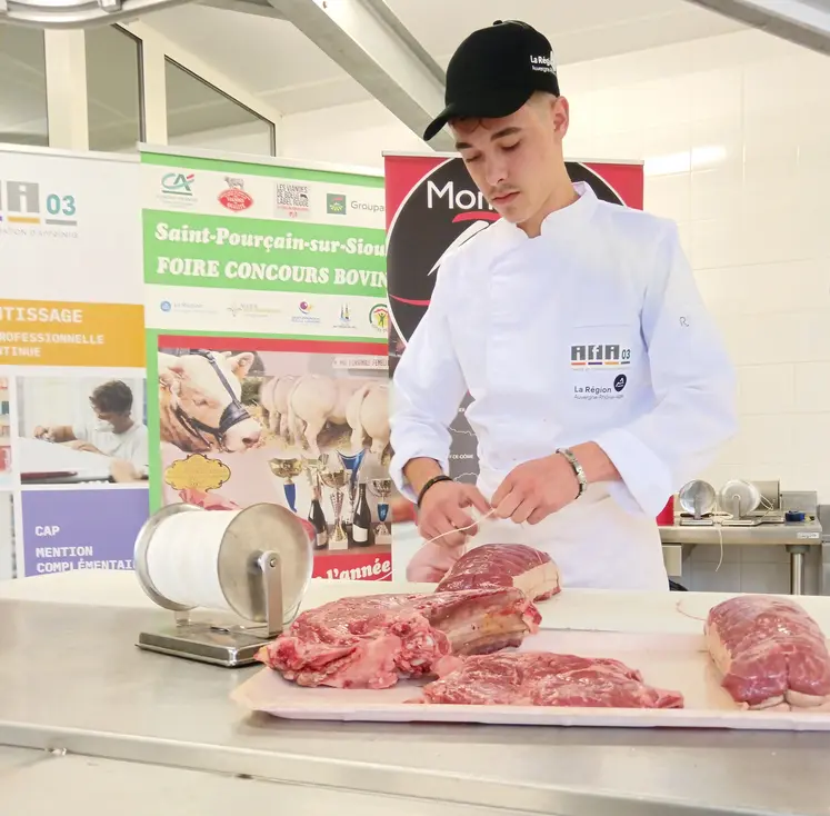 Un jeune homme ficelle un rôti de boeuf