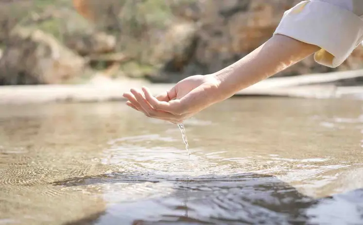 Main qui prend de l'eau dans une mare