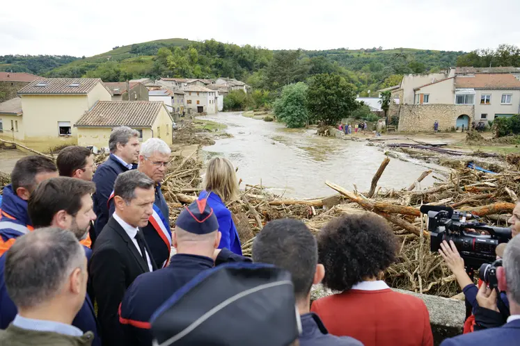 Groupe de gens devant un village inondé