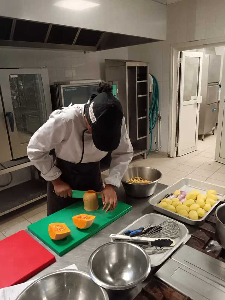 Une jeune cuisinière coupe un butternut