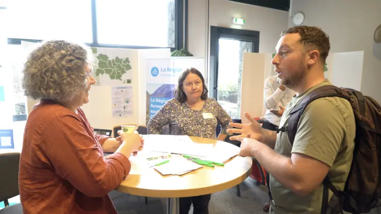 Trois personnes parlent autour d'une table