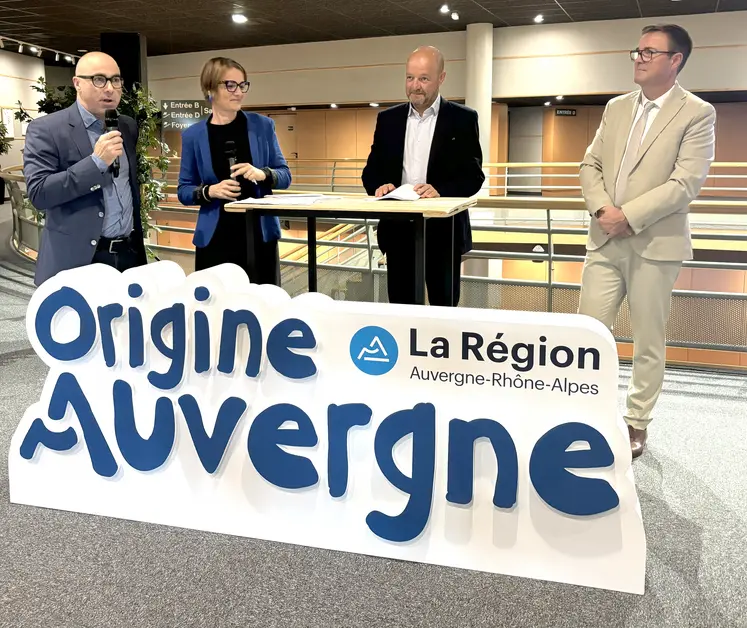 quatre personne derrière uun panneau, l'une d'entres elles tient un micro