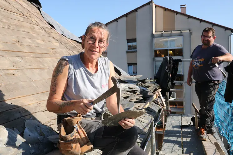 Une femme avec un marteau avec un homme sur sa gauche