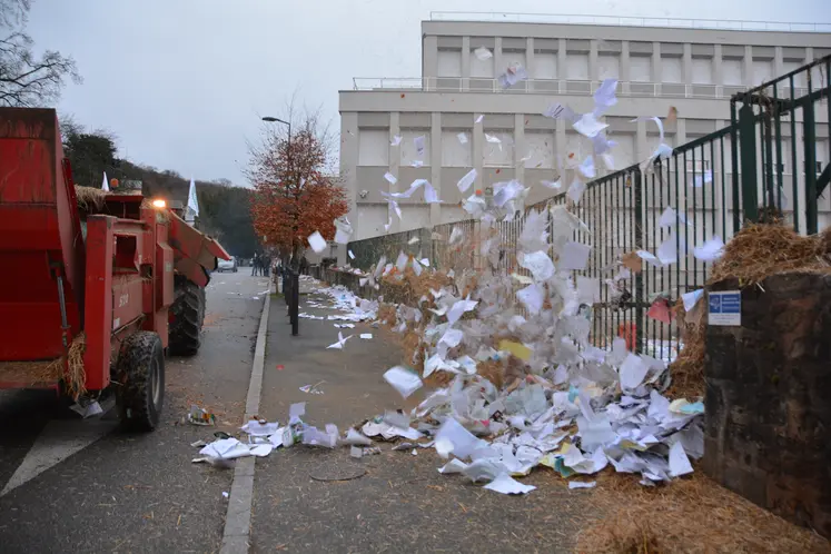 une pailleuse éjectant du papier à travers un portail