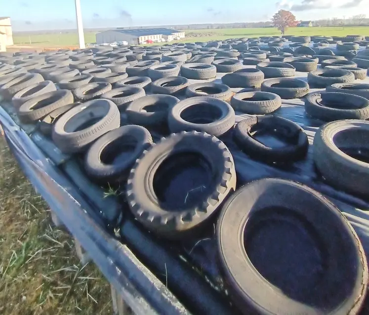 des rangées de pneus sont utilisés pour lester une bâche.