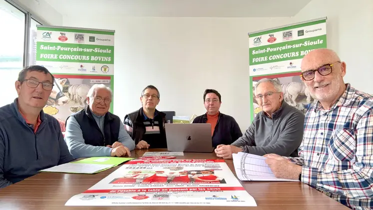 six personnes posent, assis autour d'une table