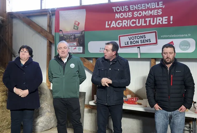 Un groupe de quatre personnes se tient devant une banderole syndicale