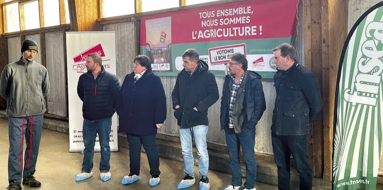 Un groupe est debout devant des affiches électorales agricoles