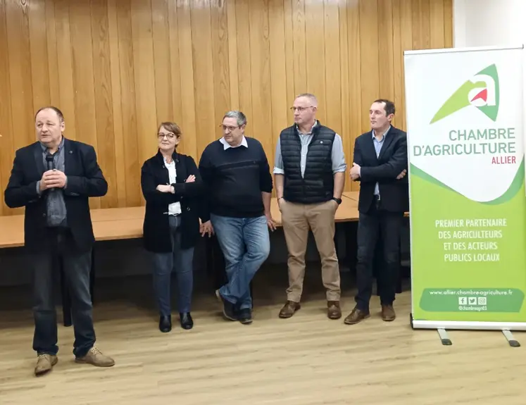 cinq personnes devant l'estrade, à côté de l'affiche de la chambre d'agriculture de l'allier