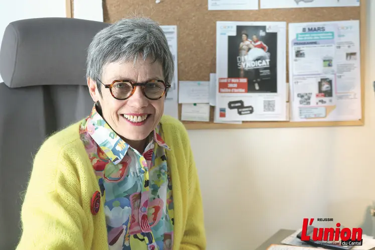 Une dame souriante assise à son bureau