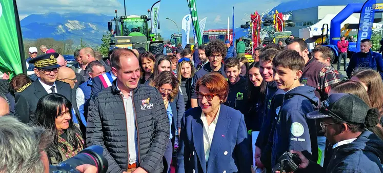 Annie Genevard, ministre de l’Agriculture au salon de Vaches en Piste 2025 entourée de journalistes et de participants.