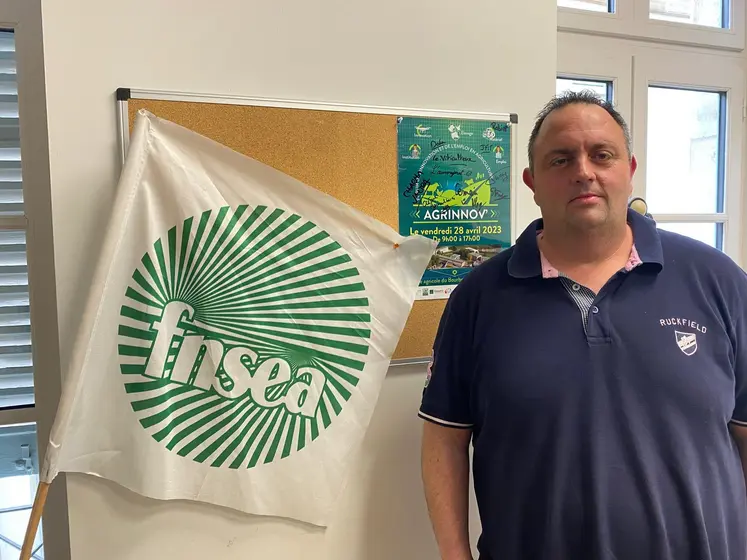 un homme a coté d'un drapeau FNSEA
