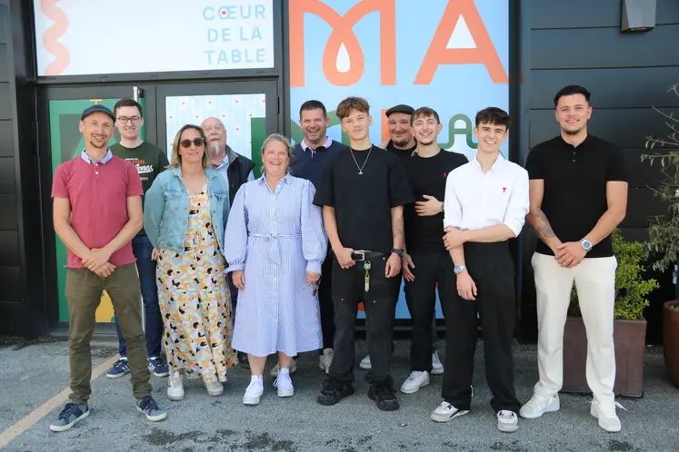 Onze personnes hommes, femmes, posant devant la devanture d'un futur restaurant.