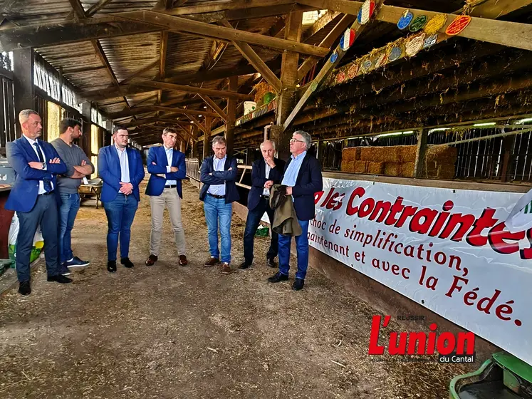 Députés et préfet sur une exploitation devant une banderolle "Basta les contraintes".