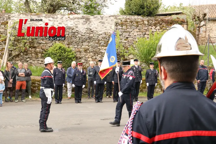 un homme avec un casque de pompier. Un homme portant un drapeau marche vers un autre homme.