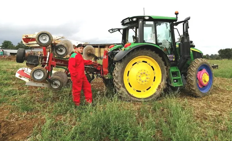 un jeune agriculteur pose devant son tracteur