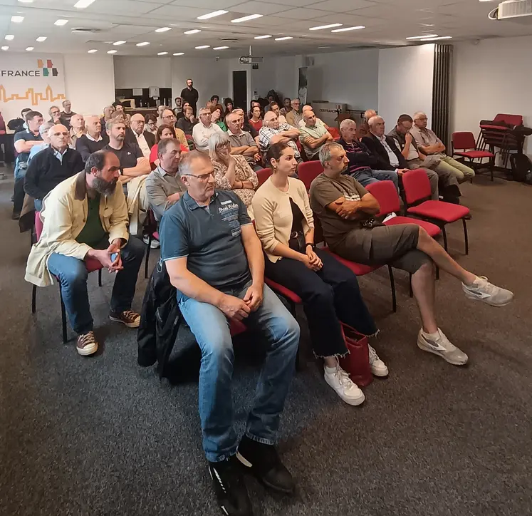 le public écoute, attentif, assis dans une salle