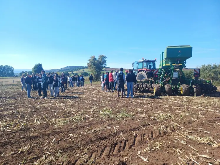 Elèves et adhérents de Cuma devant un tracteur et semoir semis-direct 6 m équipés des systèmes GPS, autoguidage, Isobus.