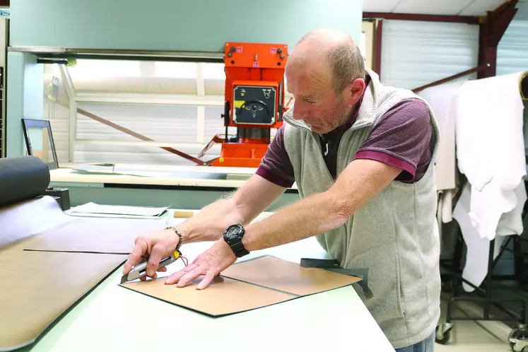 Un homme en train de découper du cuir.