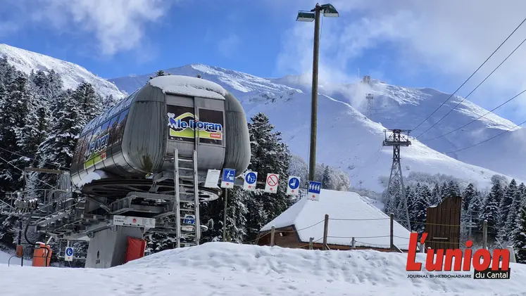 un télésiège avec la montagne enniegée en arrière plan. 