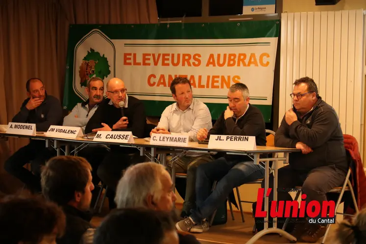 Des personnes assises derreière une table.