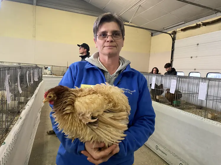 La secrétaire de l'Union Avicole Bourbonnaise pose avec une poule Pékin Frisée.