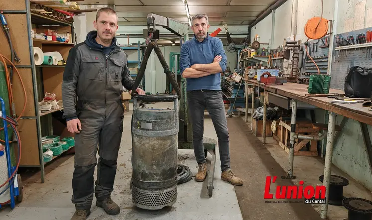 deux hommes dans un atelier autour d'une bobine de moteur électrique