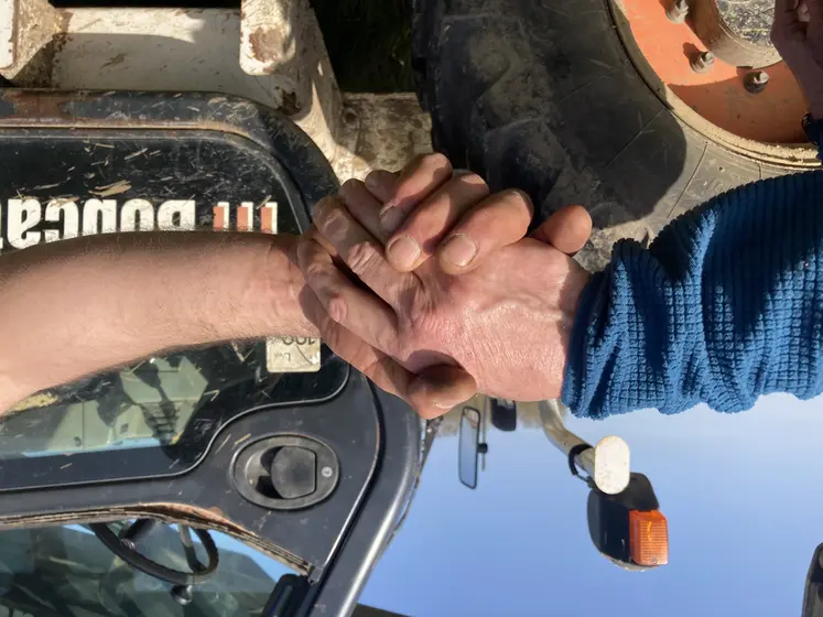 poignée de mains devant un tracteur