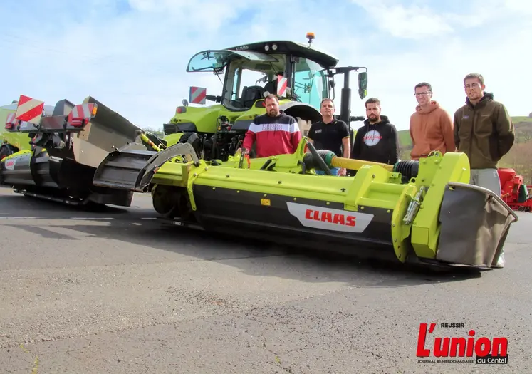 quelques agriculteurs derrière une machine de récolte de l'herbe