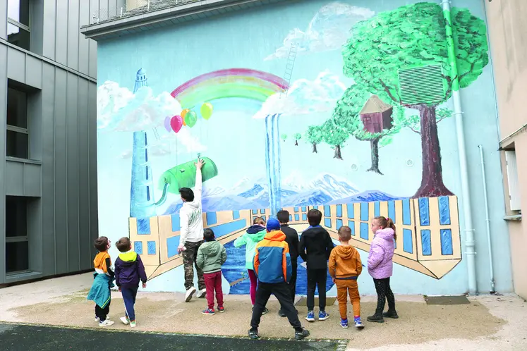 Des enfants regardent une fresque sur un mur.