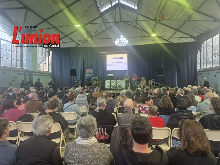 des gens de dos dans une salle avec au fond un écran lumineux