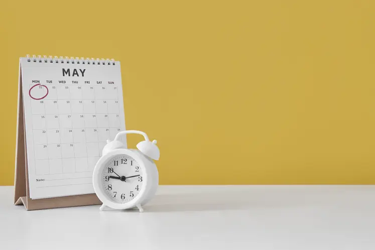 Calendrier sur une table à côté d'une horloge.