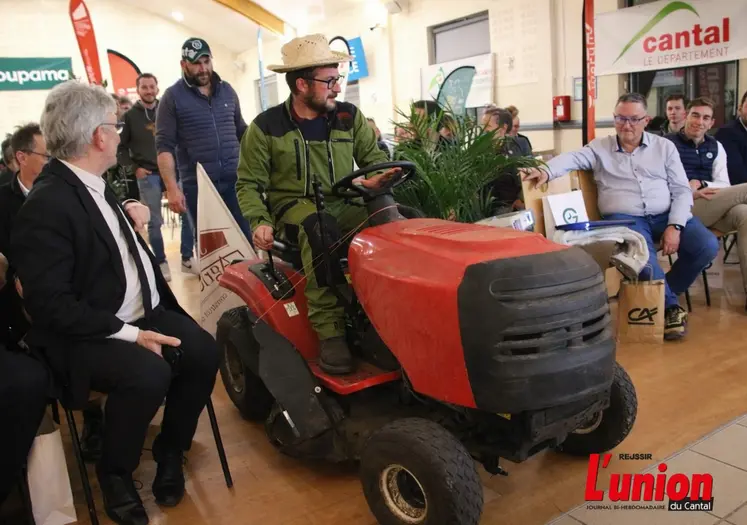 Un tracteur-tondeuse traverse une assemblée. 