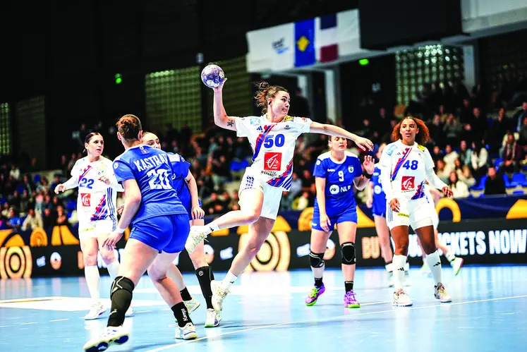 une joueuse de handball qui tente un tir en extension