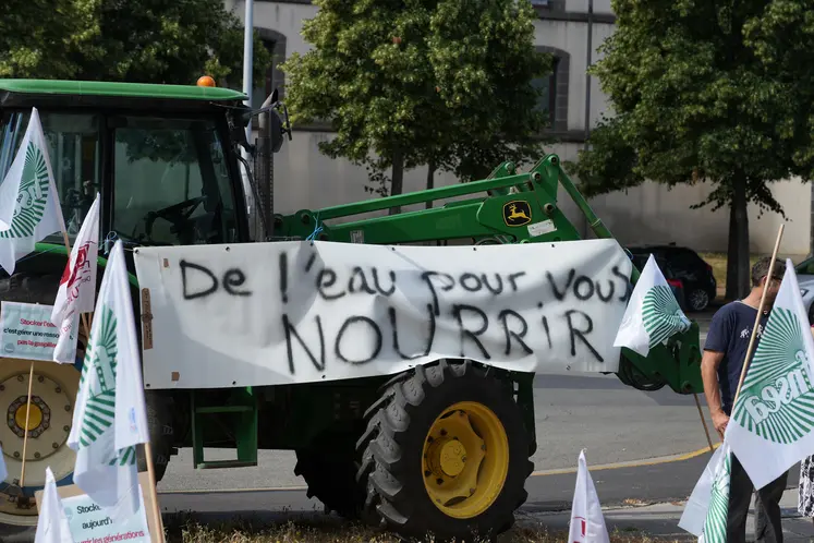 Bannière étendue sur un tracteur portant le message "De l'eau pour vous NOURRIR."