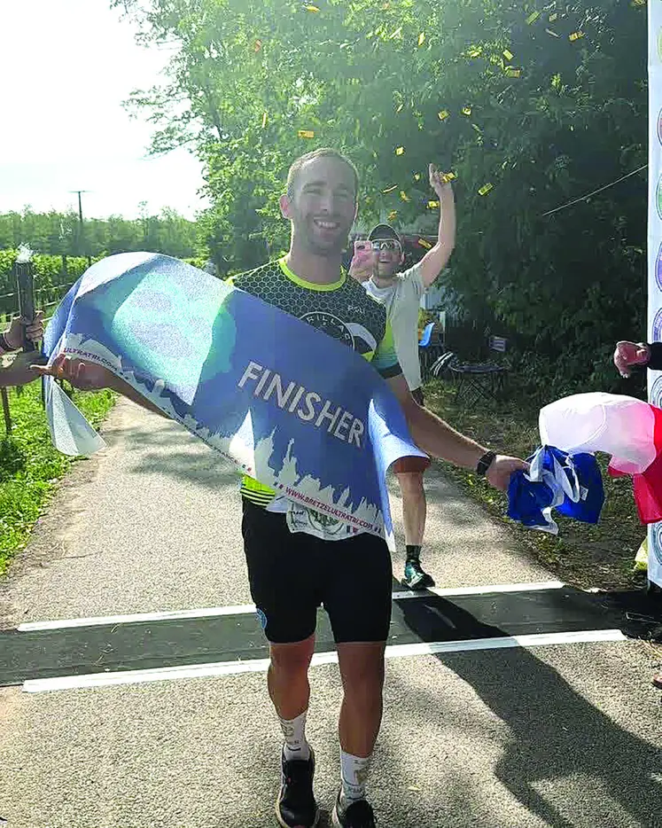 Un finisher franchit la ligne d'arrivée.