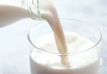 Du lait en train d'être versé dans un verre.